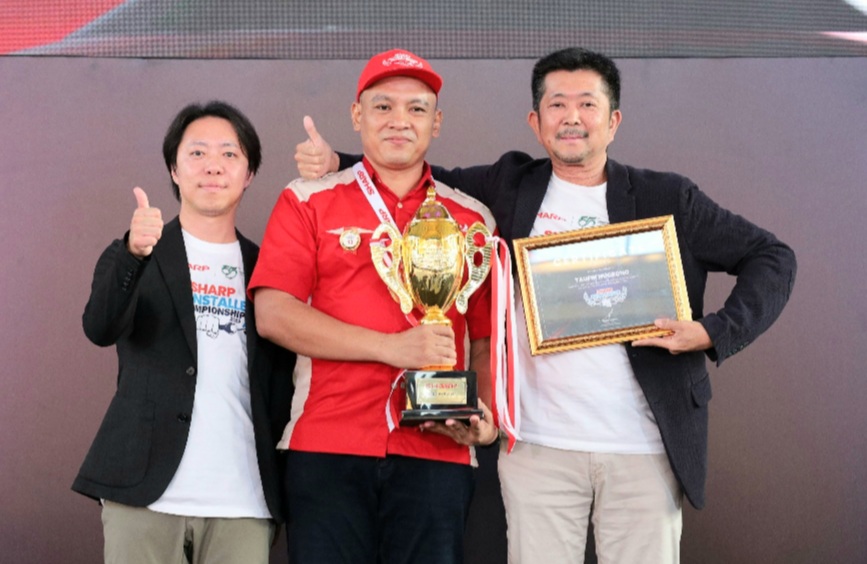 President Director, PT Sharp Electronics Indonesia, Shinji Teraoka ( kanan) dan Hideyuki Nagamine, Smart Appliances & Solution Business Unit Chairman, Sharp Corporation mengapit Taufik Nugroho juara 1 Sharp AC installer championship 2025.