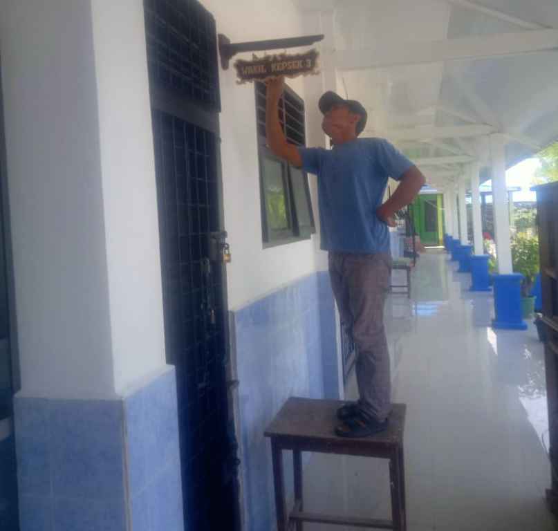 Pekerja kaligrafi tampak memperbaiki prasarana di SMPN 4 Percut Sei Tuan