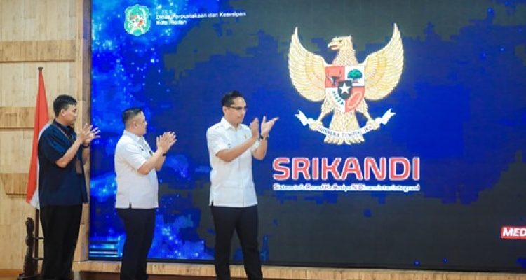 Rico Waas menempelkan telapak tangan di icon telapak tangan layar monitor untuk meluncurkan penerapan Aplikasi Sistem Informasi Kearsipan Dinamis Terintegrasi (SRIKANDI) di lingkungan Pemko Medan, Rabu (3/6/2026) di Gedung PKK Kota Medan.