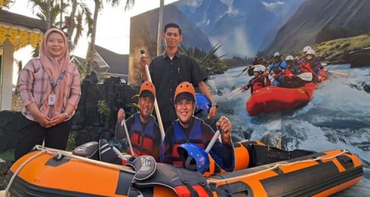Pemandu Paviliun Serdang Bedagai berfoto di depan boat arung jeram Bah Bolon di PRSU 2026 di Medan. Destinasi tersebut menjadi salah satu yang paling banyak ditanyakan selama pameran berlangsung.